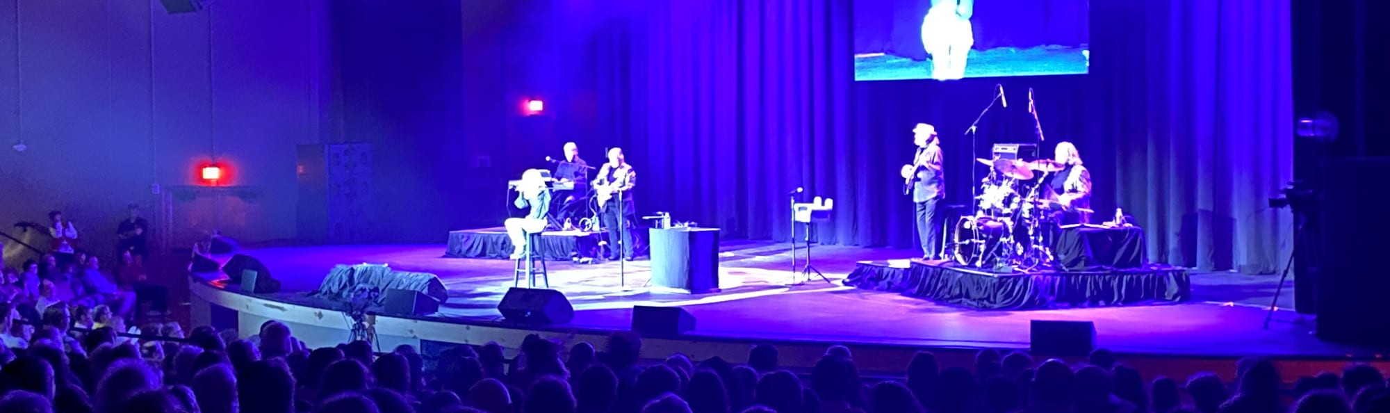 signer on stage in chair washed out by the lights Spokane